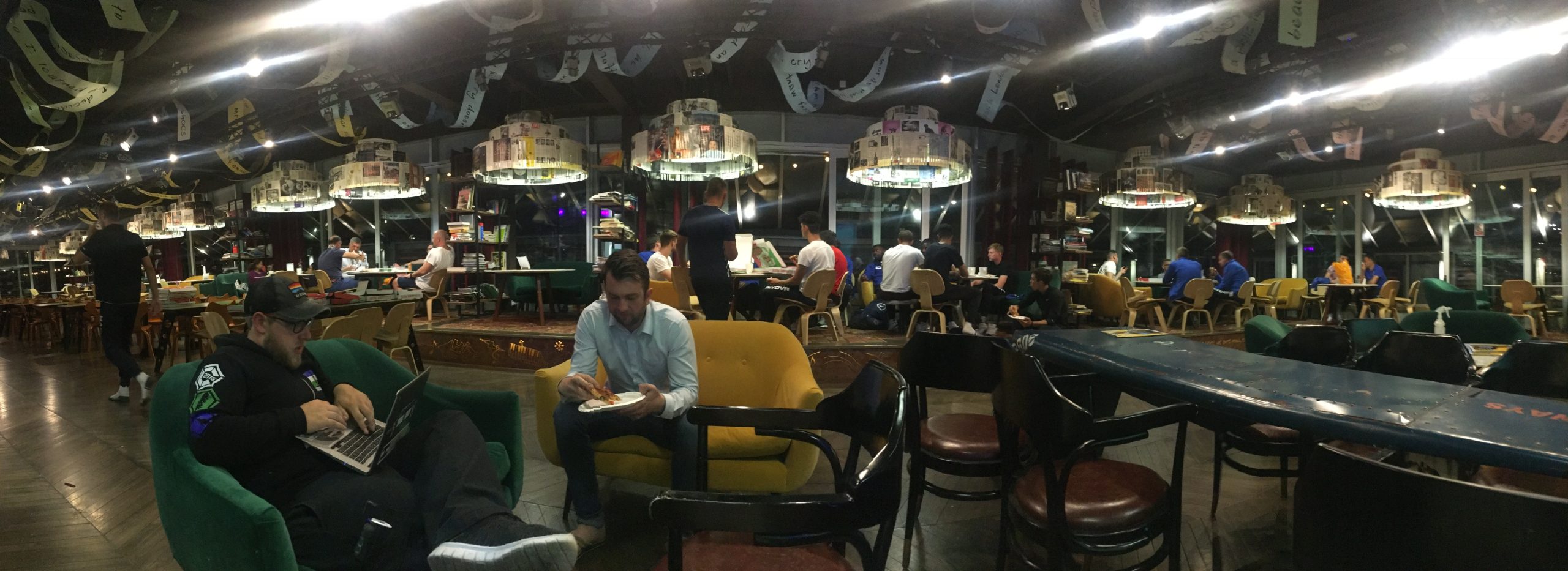 Team Cascadia enjoys a late night pizza party in a modern cafeteria in London