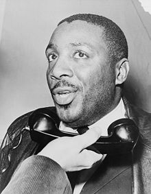 A photo of Civil Rights activist Dick Gregory talking on the phone circa 1968